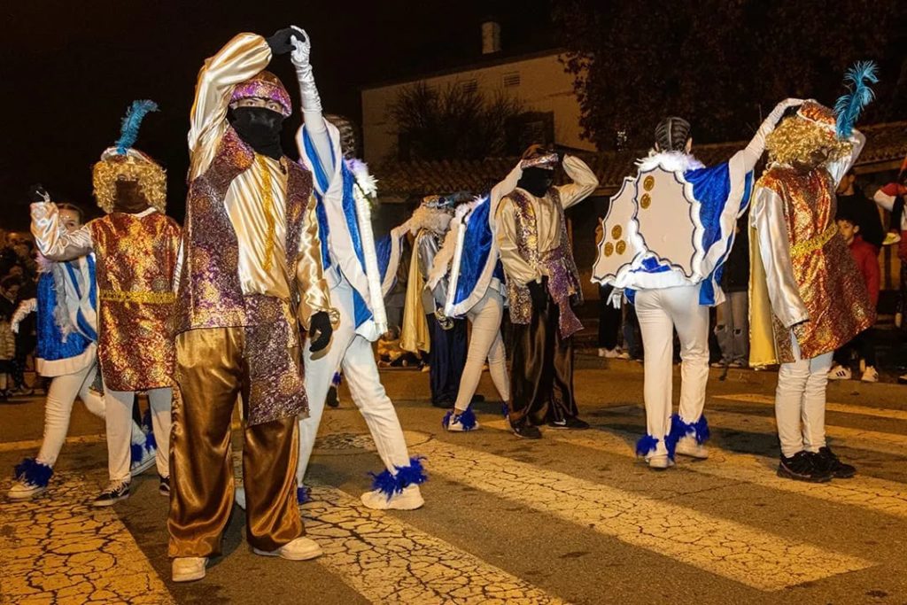 Imatge on es poden veure a les noies vestides d'àngel ballant amb els patges.