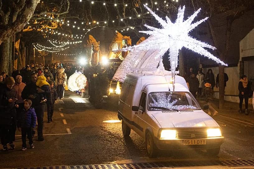 Imatge d'un cotxe carregant l'estrella de Nadal (més a prop) i altres carrosses darrera seu.