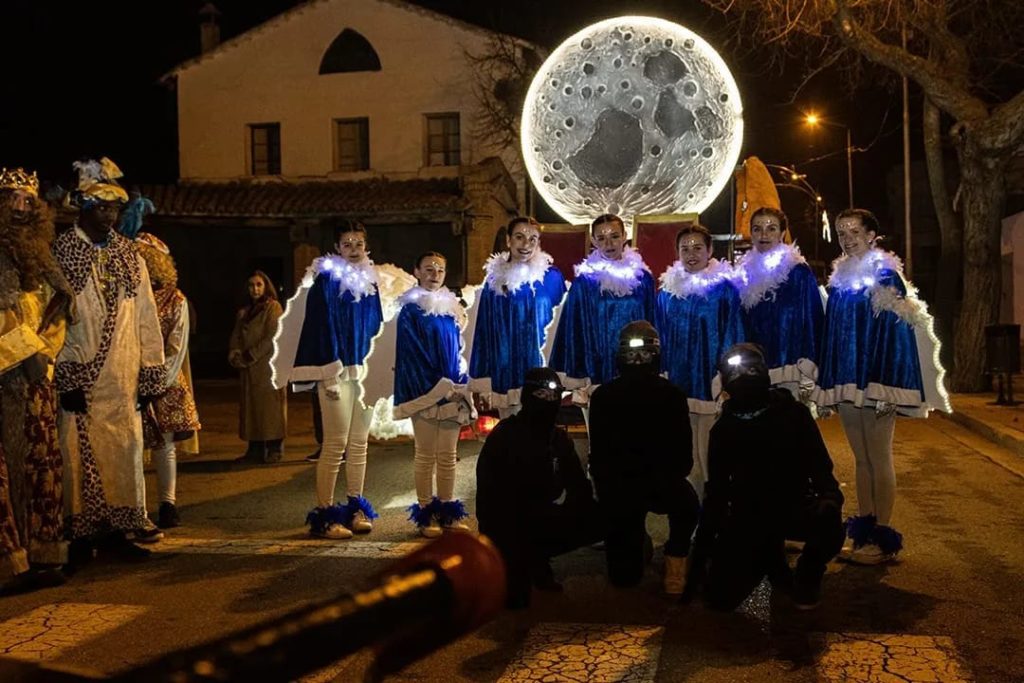 Imatges on es poden veure unes noies vestides com àngels (amb colors blaus i blancs) amb la llum en forma de lluna de fons